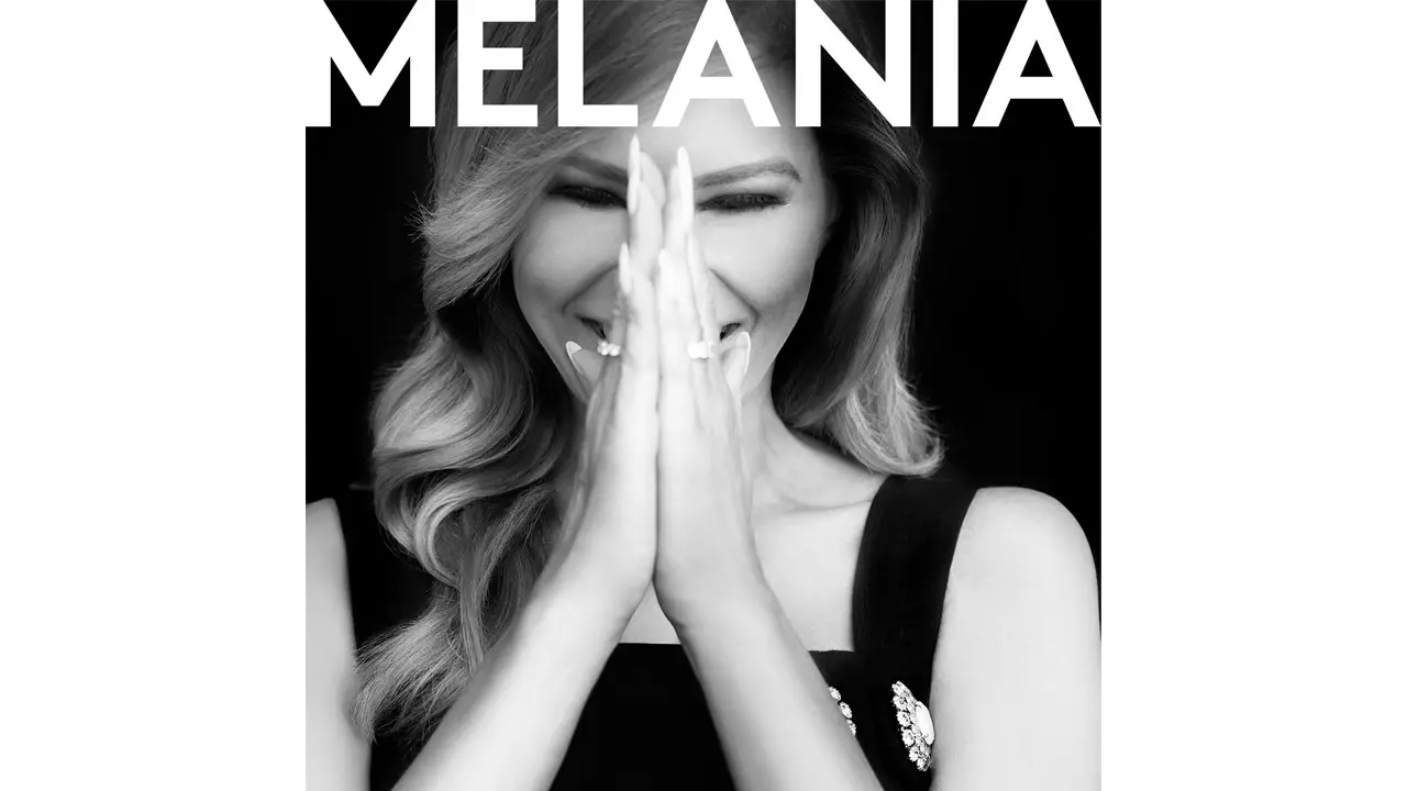 Melania, siyah-beyaz bir fotoğrafta ellerini birleştirmiş ve gülümserken tasvir edilmiş.